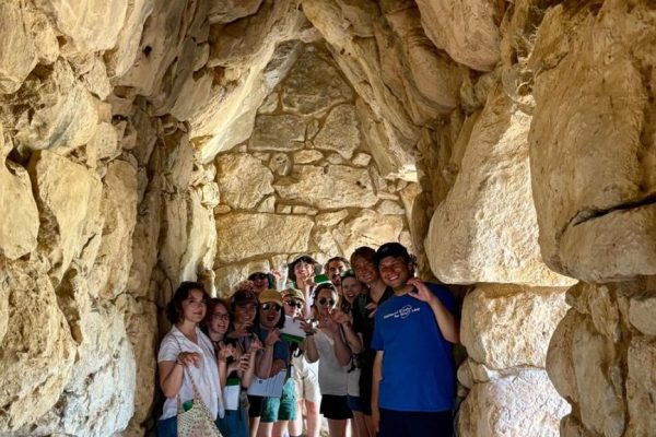 A group of students pose inside an ancient structure in Greece